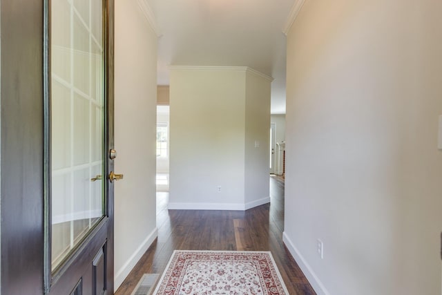 foyer featuring crown molding, baseboards, and dark wood-style floors