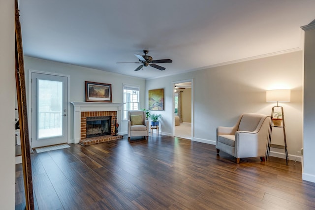 sitting room with ornamental molding, wood finished floors, and a fireplace