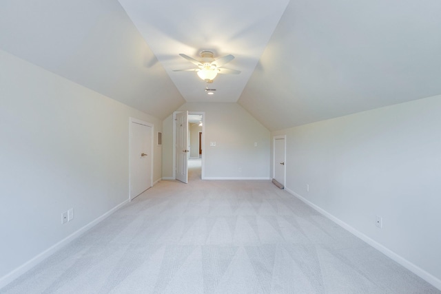 additional living space with baseboards, a ceiling fan, lofted ceiling, and light carpet