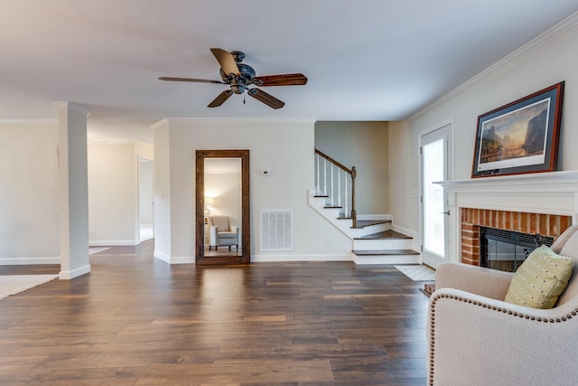living area with a fireplace, a ceiling fan, wood finished floors, visible vents, and stairway