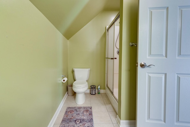bathroom with a shower stall, vaulted ceiling, tile patterned floors, baseboards, and toilet
