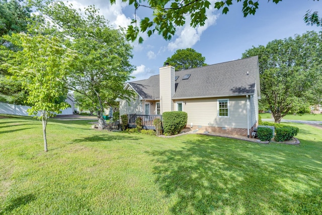 exterior space with a lawn, a chimney, a shingled roof, and a wooden deck
