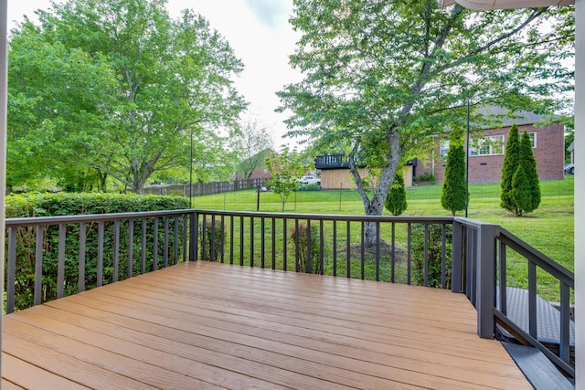 wooden deck with a lawn and fence