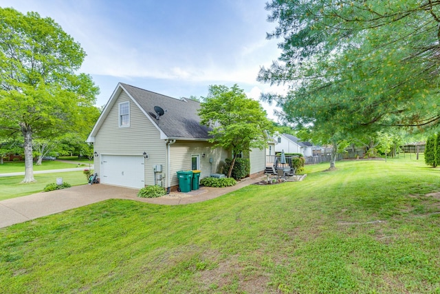 view of side of property featuring a garage, a yard, driveway, and a shingled roof