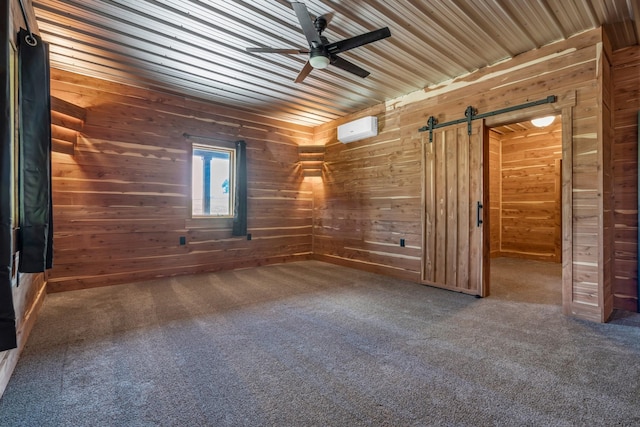 empty room with a barn door, ceiling fan, a wall mounted AC, and wood walls