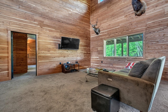 living room with carpet floors, a high ceiling, and wooden walls