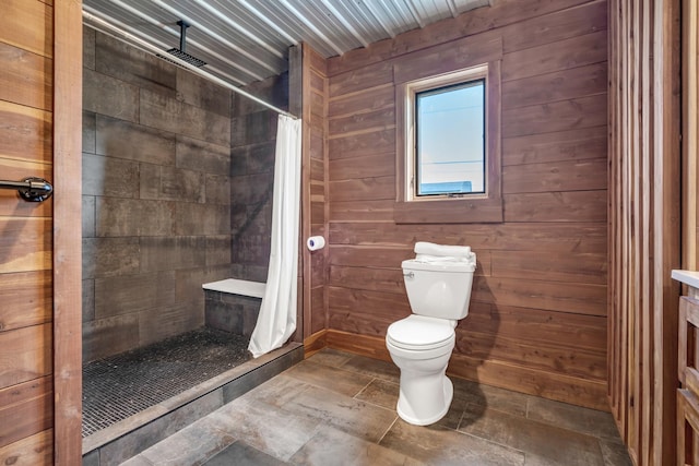 full bathroom featuring toilet, wood walls, and a tile shower