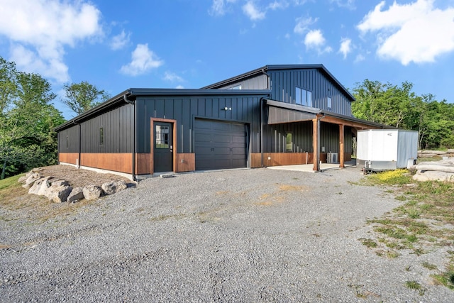 exterior space featuring board and batten siding and gravel driveway