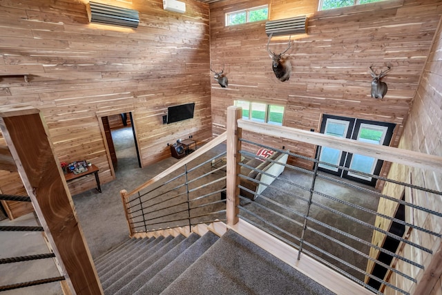 stairs featuring carpet flooring and wood walls