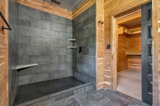 bathroom featuring wooden walls and a tile shower