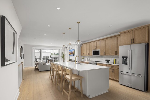 717 41st Ave N, Nashville, TN 37209 - kitchen with stainless steel appliances, light countertops, light wood-style floors, a kitchen bar, and recessed lighting
