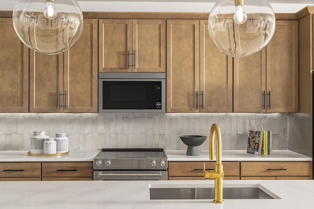 717 41st Ave N, Nashville, TN 37209 - kitchen featuring stainless steel appliances, a sink, brown cabinets, and tasteful backsplash