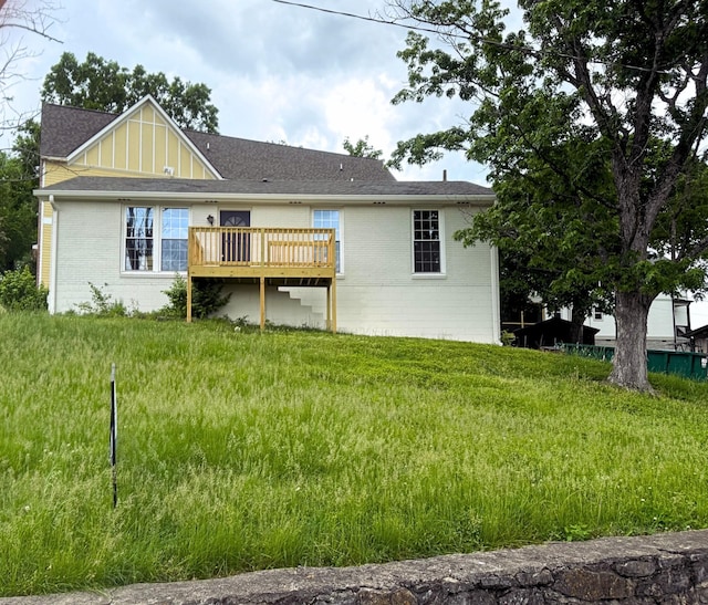 back of property featuring board and batten siding, a wooden deck, a shingled roof, and brick siding