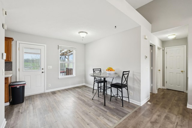 dining area with baseboards and wood finished floors