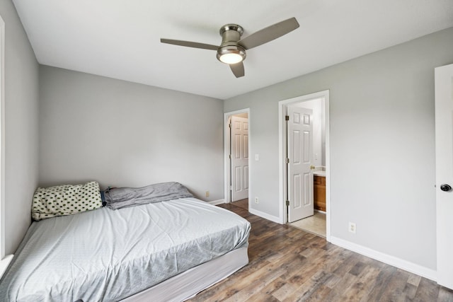 bedroom with baseboards, a ceiling fan, wood finished floors, and connected bathroom