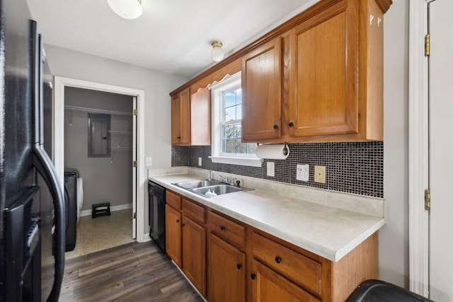 kitchen with light countertops, brown cabinetry, a sink, and black appliances