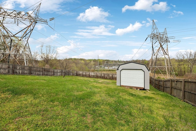 view of yard with an outdoor structure, a fenced backyard, and a shed