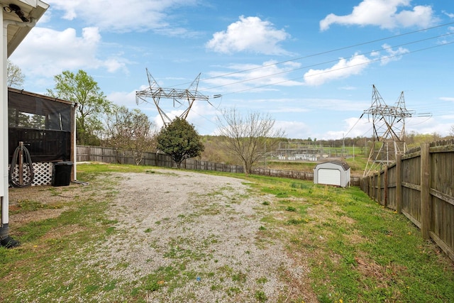 view of yard with a fenced backyard, an outbuilding, a sunroom, and a shed