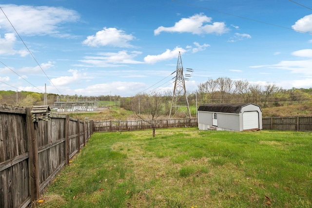 view of yard featuring an outdoor structure, a fenced backyard, and a garage