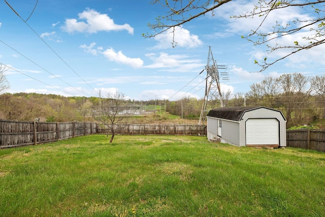 view of yard featuring an outdoor structure, a garage, a fenced backyard, and a shed
