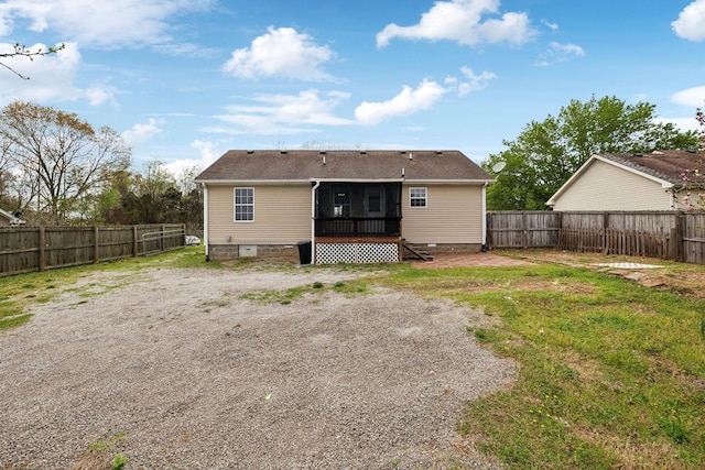 rear view of house featuring crawl space, a fenced backyard, and a sunroom