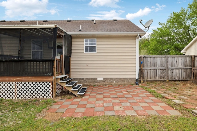 back of house featuring fence and a shingled roof