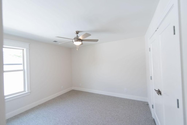 unfurnished room featuring baseboards, ceiling fan, and light colored carpet
