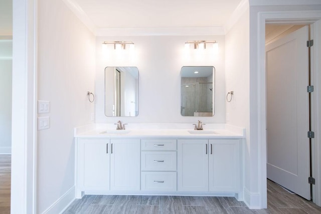 bathroom featuring double vanity, baseboards, a shower stall, and a sink