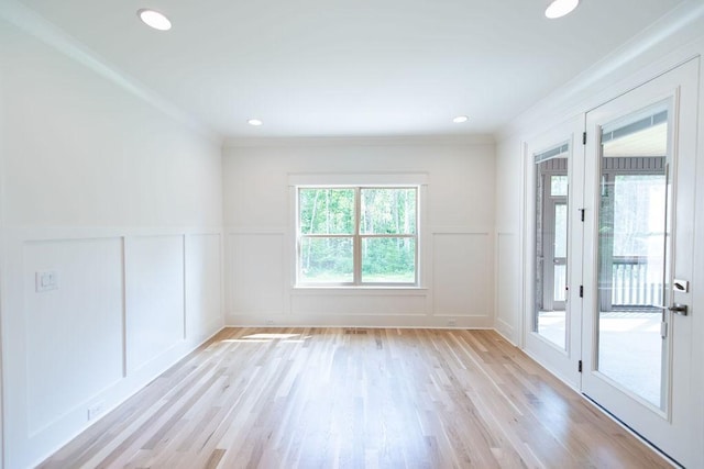 spare room with light wood finished floors, a decorative wall, a wainscoted wall, recessed lighting, and ornamental molding