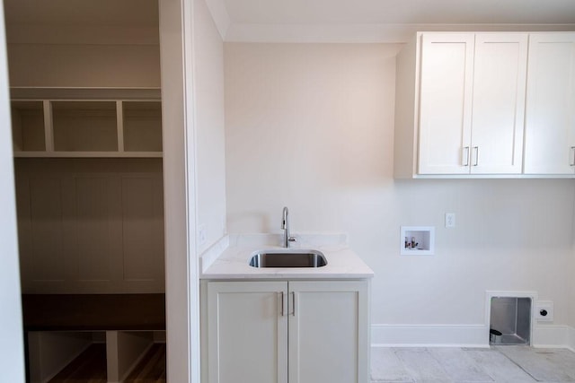 washroom featuring electric dryer hookup, cabinet space, a sink, baseboards, and hookup for a washing machine