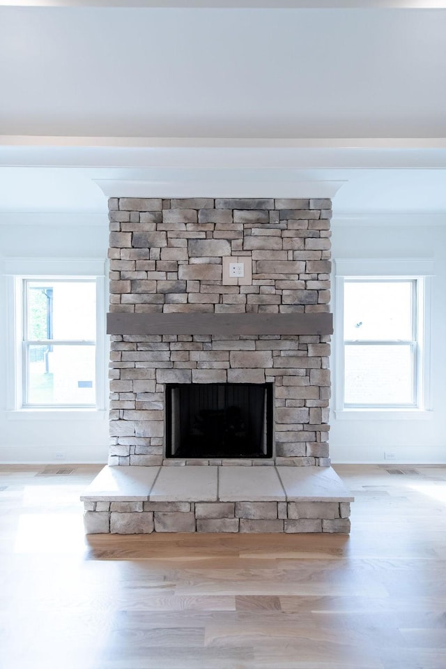 details with a fireplace, wood finished floors, and visible vents