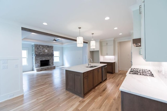 kitchen featuring crown molding, ceiling fan, appliances with stainless steel finishes, a sink, and light wood-type flooring