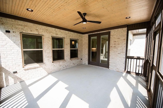 unfurnished sunroom with a ceiling fan and french doors