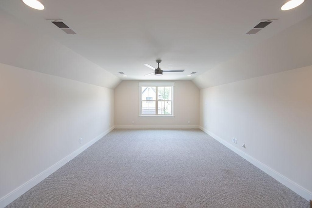 additional living space with visible vents, light carpet, and lofted ceiling