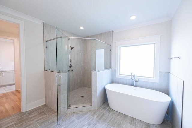 full bathroom featuring recessed lighting, wood finished floors, a soaking tub, and a shower stall