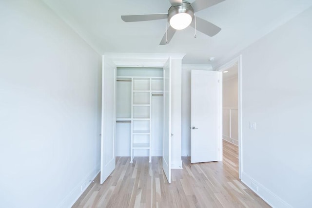 unfurnished bedroom with a ceiling fan, baseboards, light wood-style flooring, and a closet