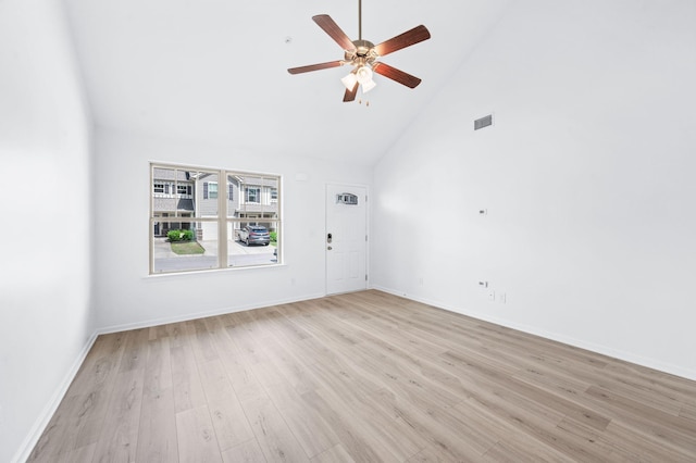 interior space with light wood-style floors, a ceiling fan, baseboards, and high vaulted ceiling