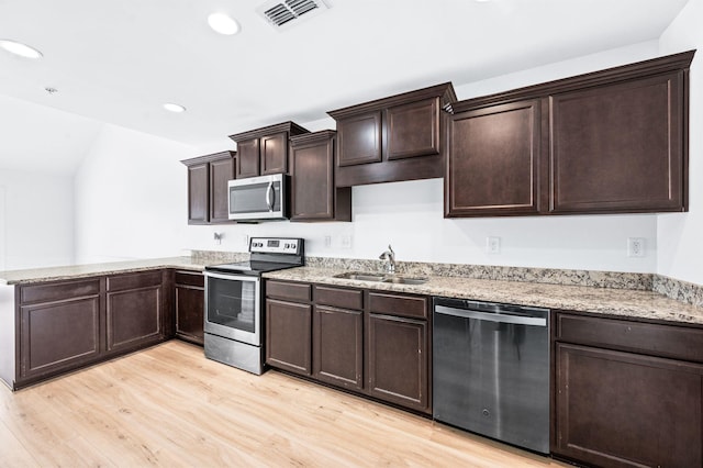 kitchen with visible vents, dark brown cabinetry, light wood-style floors, a sink, and appliances with stainless steel finishes