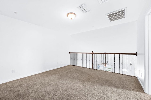 empty room with carpet flooring, baseboards, and visible vents