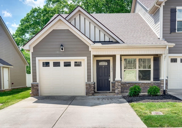 view of front of property featuring a garage, stone siding, a shingled roof, board and batten siding, and driveway