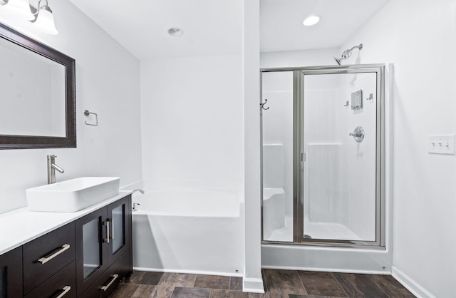full bathroom with a garden tub, a stall shower, vanity, baseboards, and recessed lighting