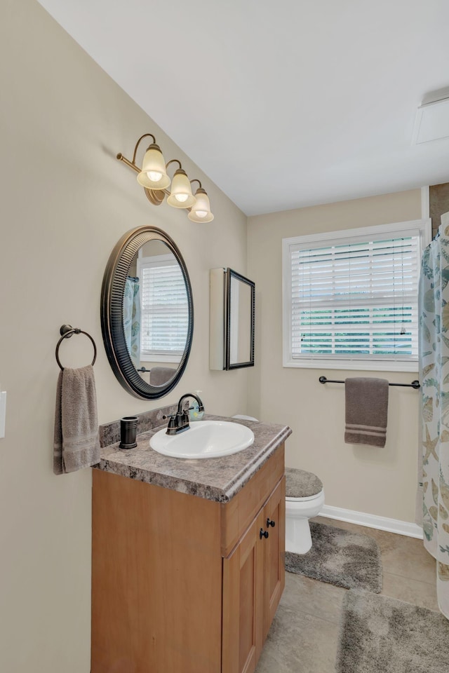 bathroom with vanity, tile patterned floors, baseboards, and toilet