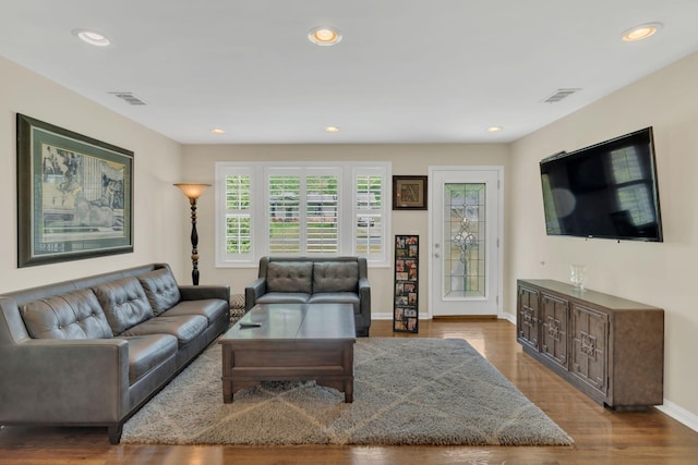 living area with recessed lighting, baseboards, visible vents, and wood finished floors