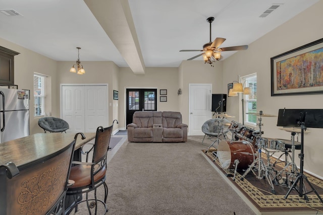 living room featuring visible vents, carpet floors, a healthy amount of sunlight, and ceiling fan