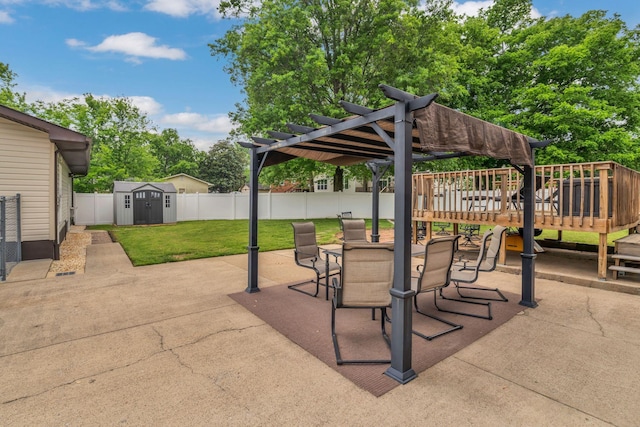 view of patio / terrace featuring a pergola, a storage shed, a wooden deck, a fenced backyard, and an outbuilding