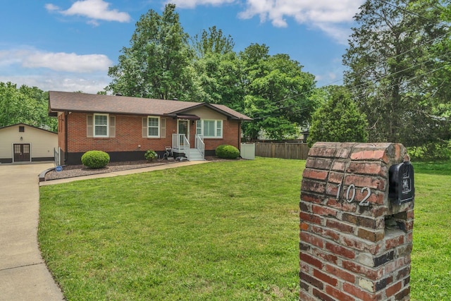 ranch-style home with brick siding, fence, a front yard, and concrete driveway
