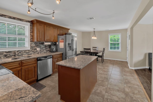 kitchen with visible vents, brown cabinets, tasteful backsplash, a sink, and appliances with stainless steel finishes