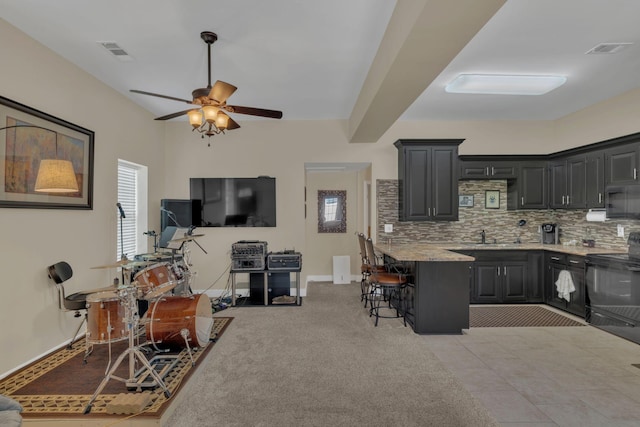 kitchen featuring a breakfast bar, open floor plan, ceiling fan, tasteful backsplash, and black / electric stove
