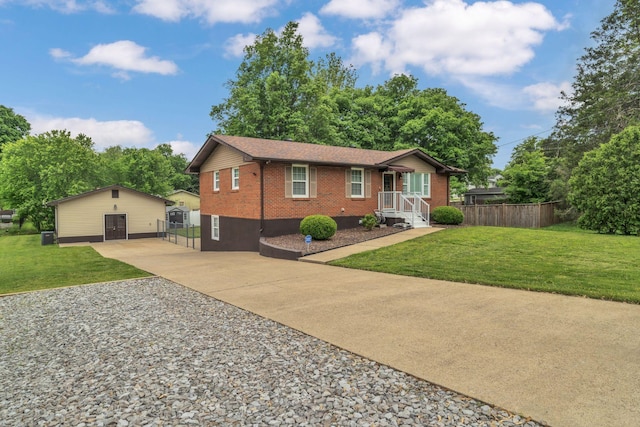 ranch-style house featuring fence, concrete driveway, a front yard, and brick siding