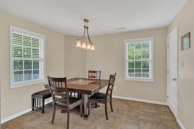 dining space with baseboards, visible vents, and a wealth of natural light